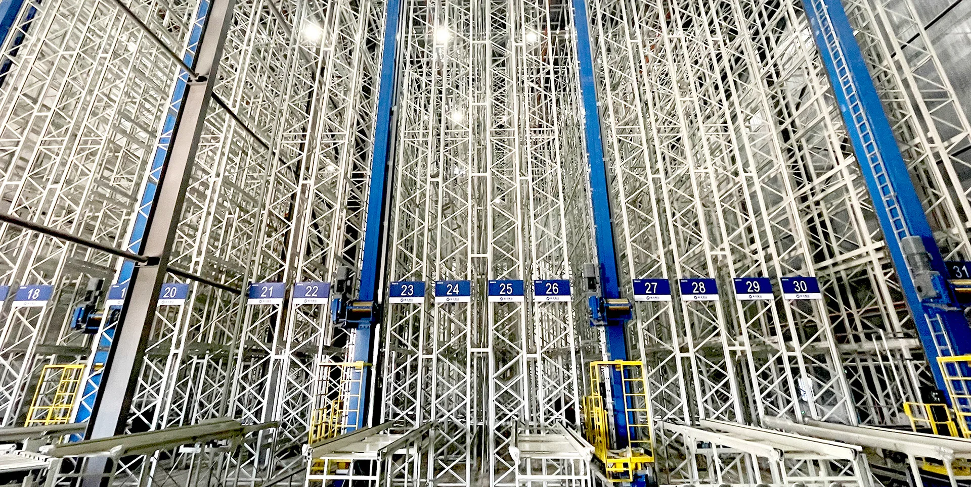 SSTC industrial automated storage and retrieval system AS/RS stacker crane operating in a high-bay warehouse