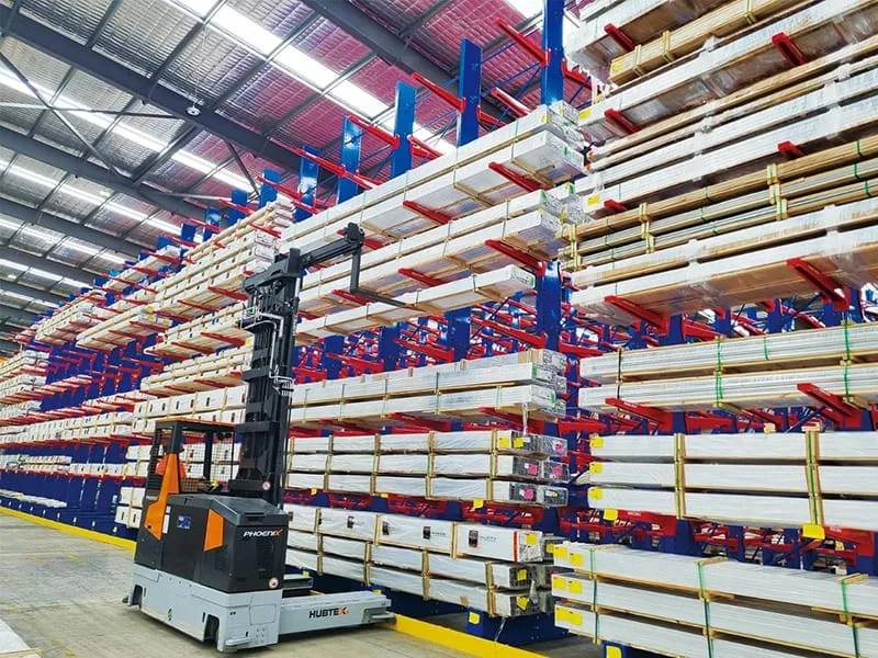 Heavy-duty cantilever racking system installed in a modern warehouse storing long steel profiles, pipes, and tubes by SSTC Intelligence