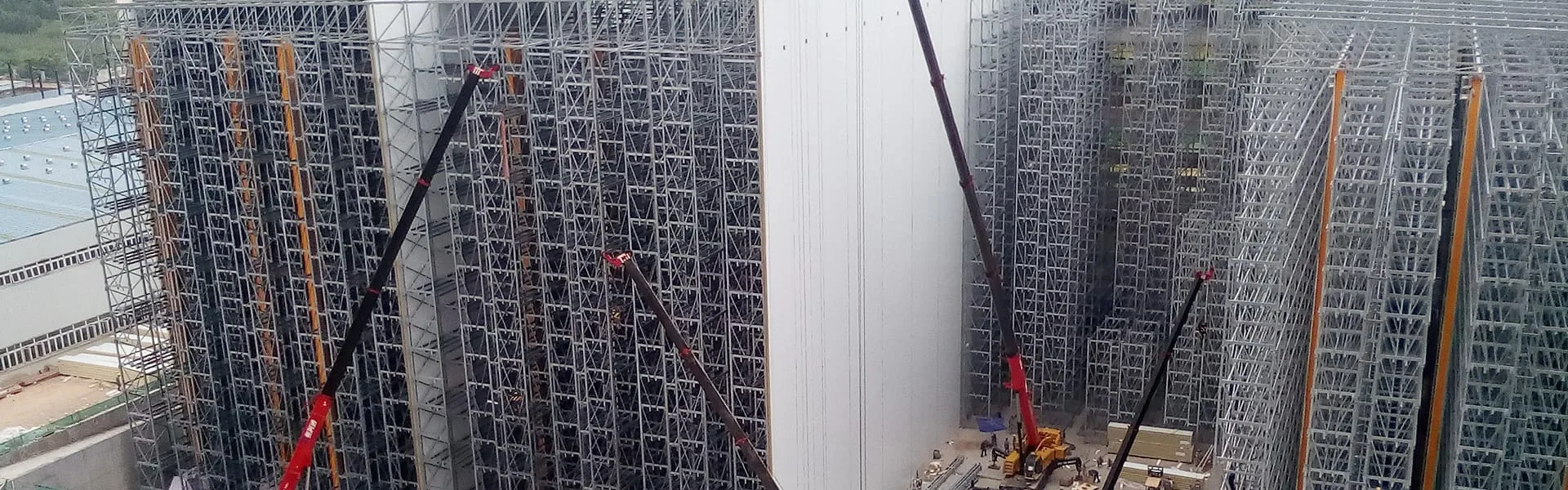 SSTC Intelligence field installation team performing precision guide rail leveling and structural racking assembly for high-rise automated warehouses