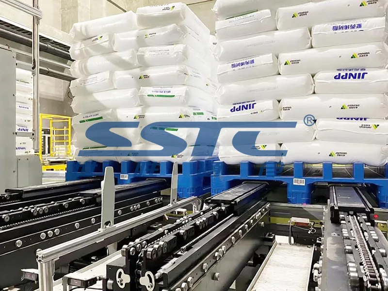 Heavy-duty automated roller conveyor line transferring chemical material pallets into high-bay Pallet AS/RS staging area engineered by SSTC Intelligence